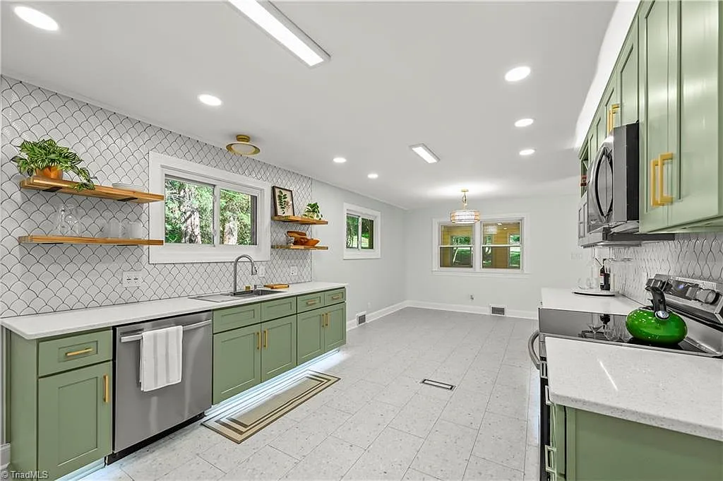 Modern renovated kitchen with sage green cabinets and quartz countertops in a home sold by Rob Herald Realty in the NC Triad
