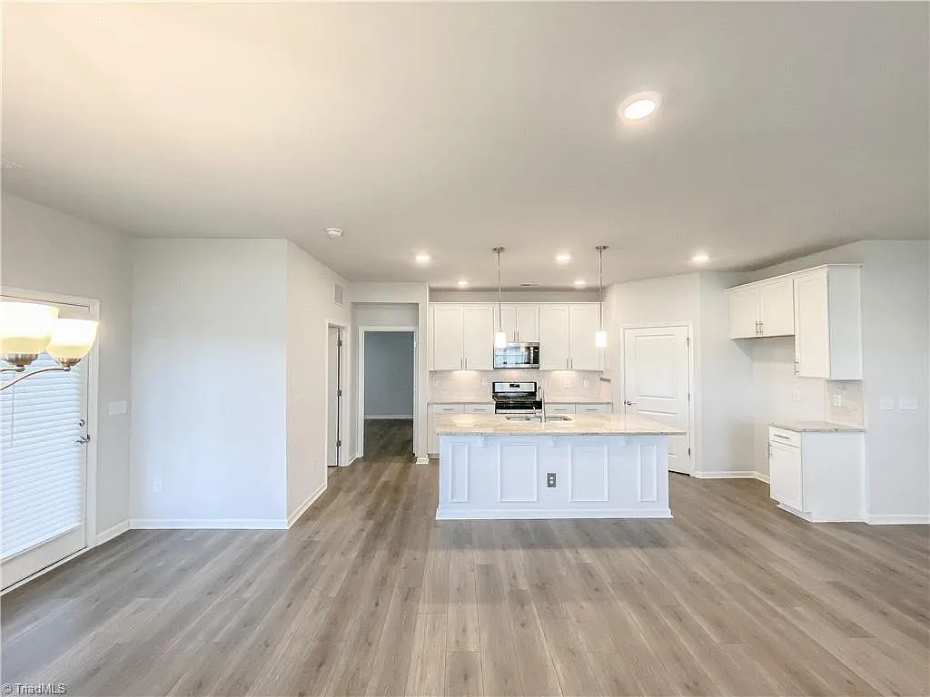 Open concept kitchen with white cabinets and center island in a home sold by Rob Herald Realty in the NC Triad